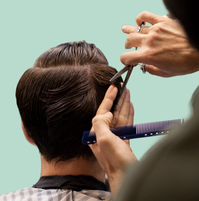 Professional barber cutting a client’s hair with precision, representing premium grooming and appointment booking at Eddine Belaid Barber School.