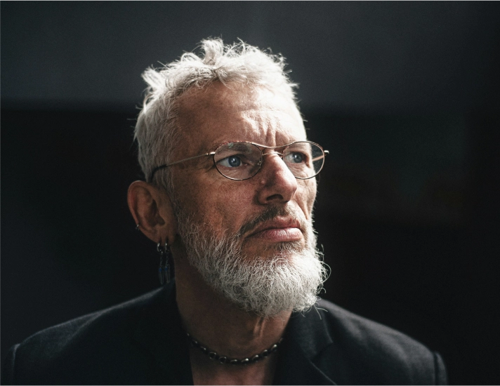 Stylish mature man with a grey beard, representing the modern revival of classic barbers and timeless beard grooming trends at Eddine Belaid Barber Shop.