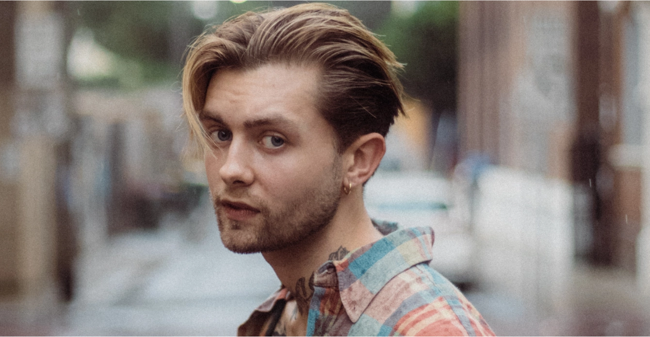 Stylish young man with trendy blonde hairstyle, representing modern barber trends and fashion insights from Eddine Belaid’s Barber Blog.
